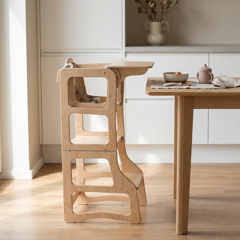 Wooden chair and table in a modern kitchen with white cabinets and a vase on the counter.