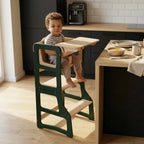 Child using a high chair at a kitchen island with fruits and a coffee maker in the background.