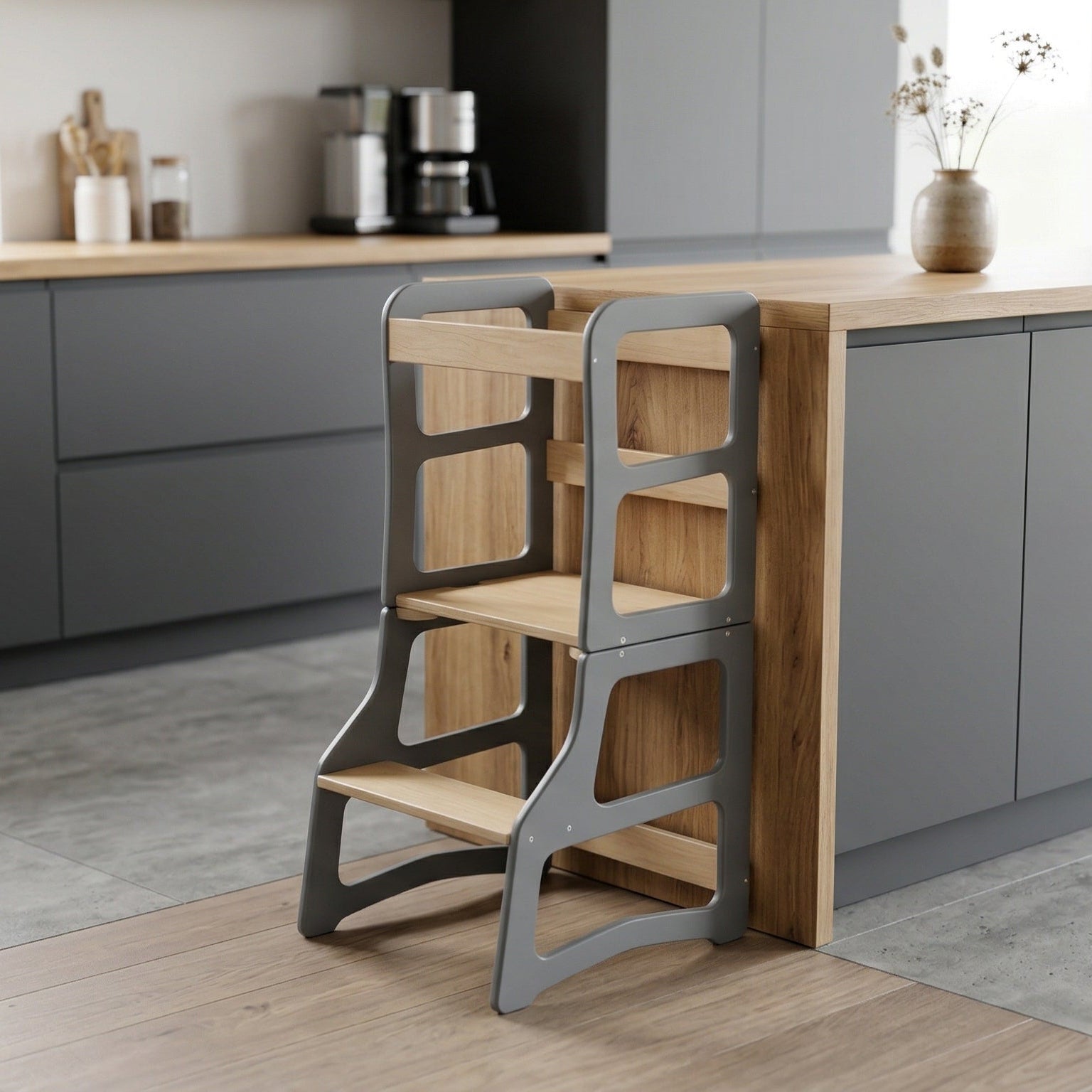 Wooden step stool against a kitchen counter with gray cabinets and wooden flooring.